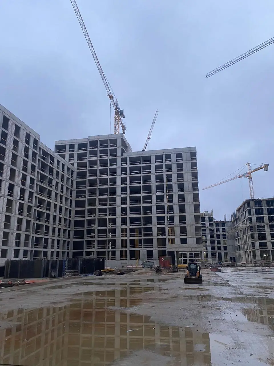 Несколько башенных кранов на объекте высотного строительства